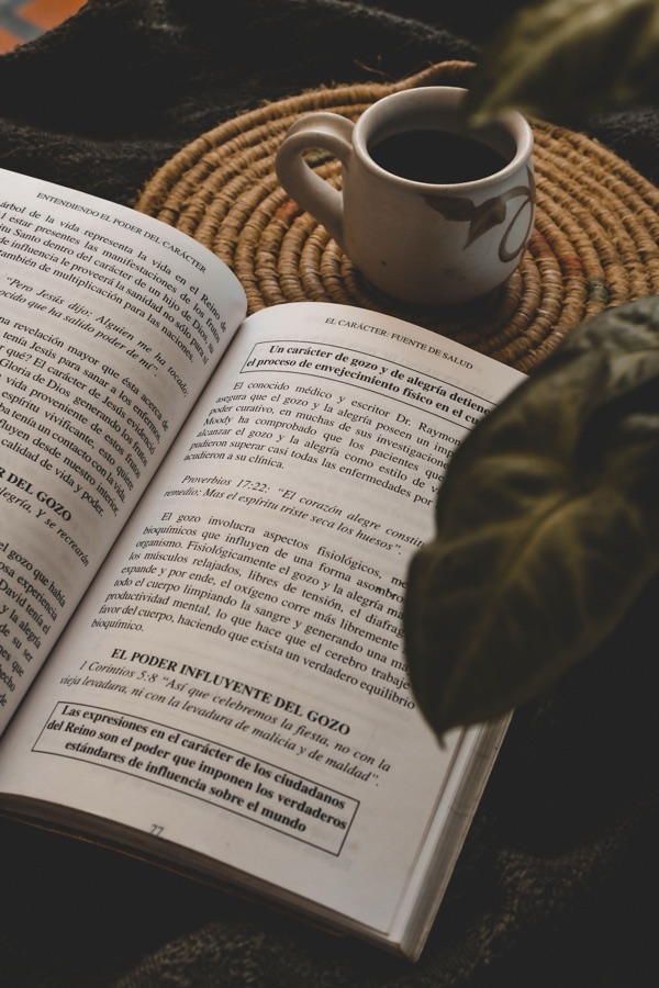 Libro abierto con taza de café — libros espirituales recomendados